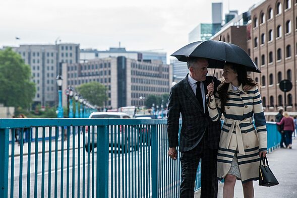 man and woman standing beside blue metal fence during daytime