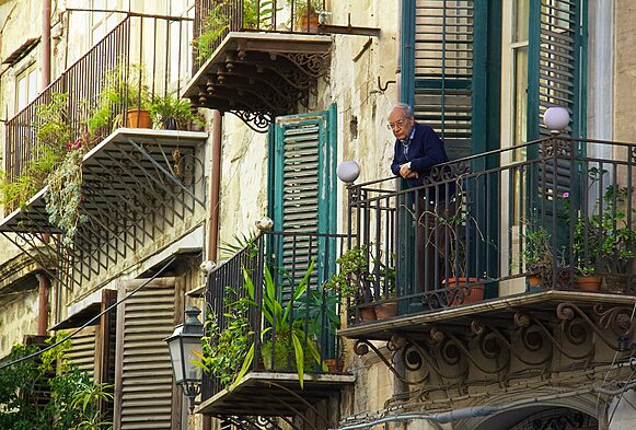 social isolation, man in blue jacket standing on the balcony, Unveiling the Risks of the Indoor Lifestyle - The Rise of Sedentary Lifestyles and Mental Health Consequences of Indoor Generation