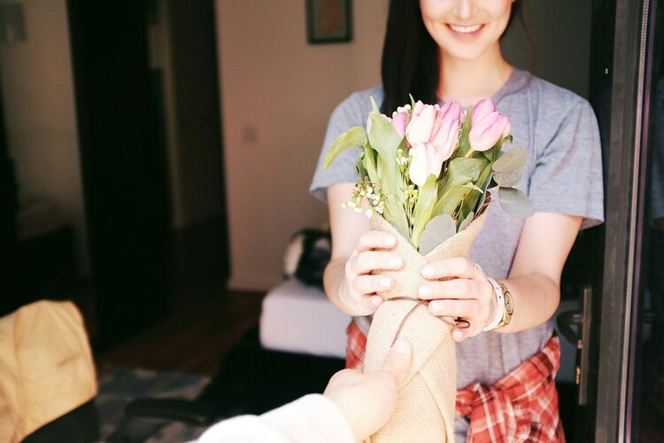 woman holding flower bouquets saying thanks in relationship