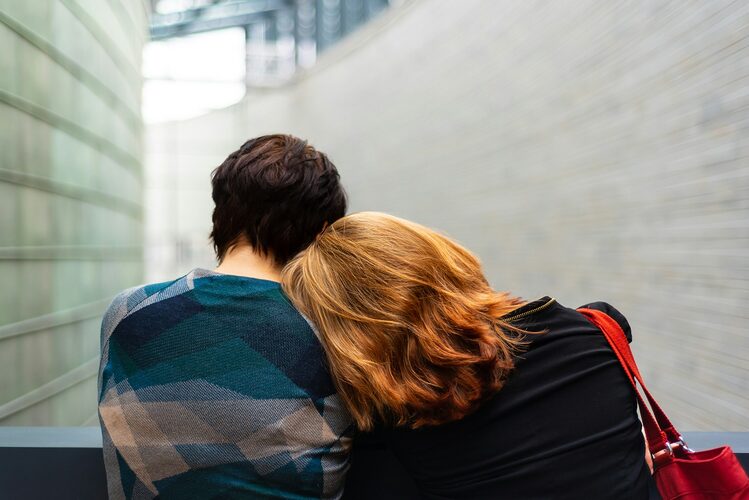 empathy in relationship, a woman rests her head on another person's shoulder